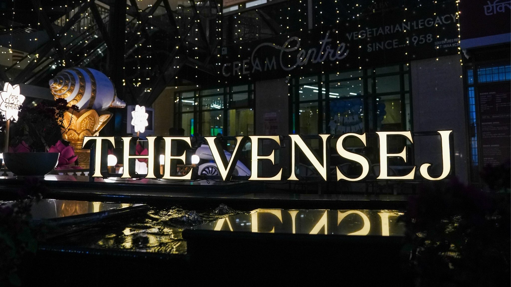 Best mall on Golf Course Extension Gurgaon showcasing The Vensej Mall entrance with illuminated signage and modern retail spaces at night
